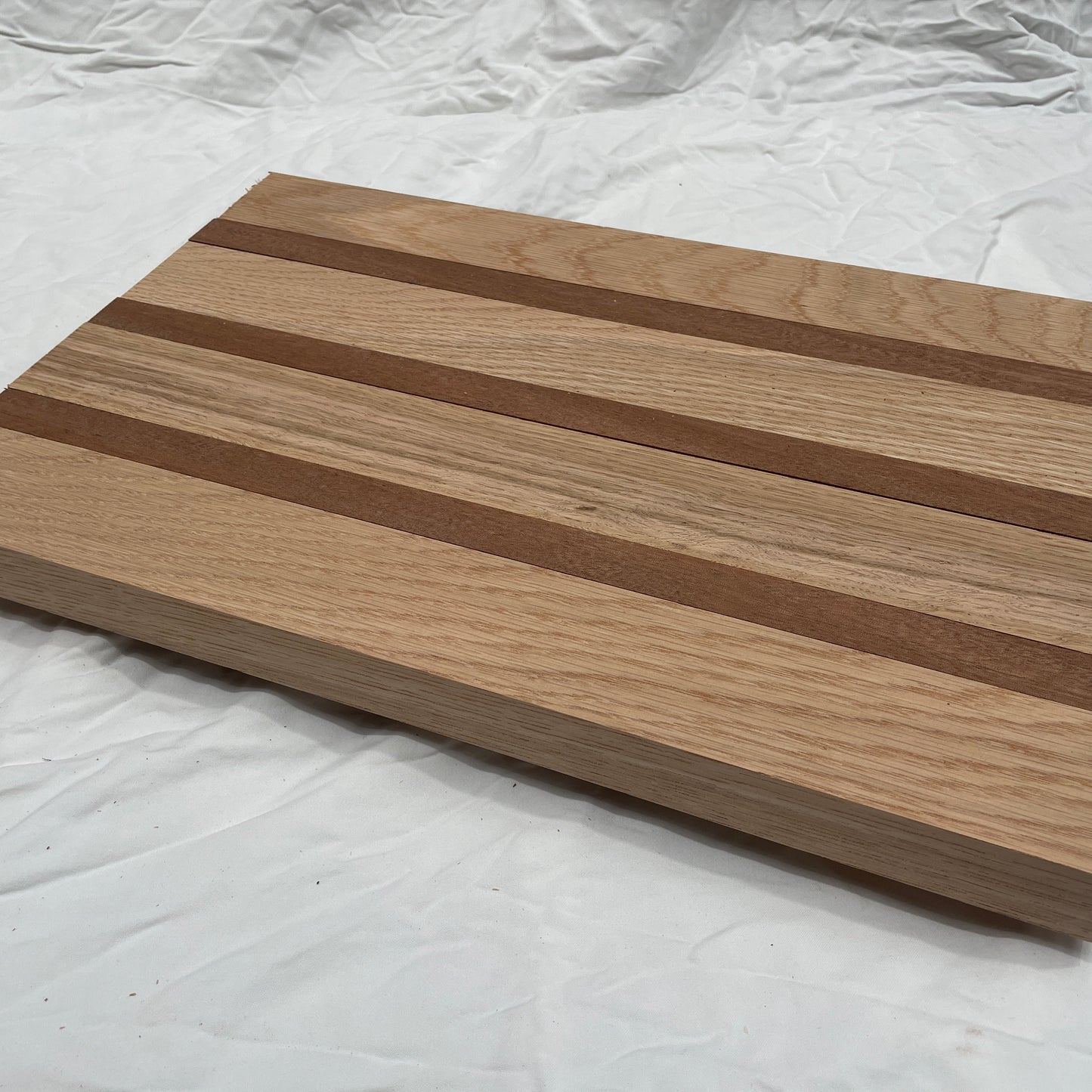 Wooden cutting board with striped pattern on a white background