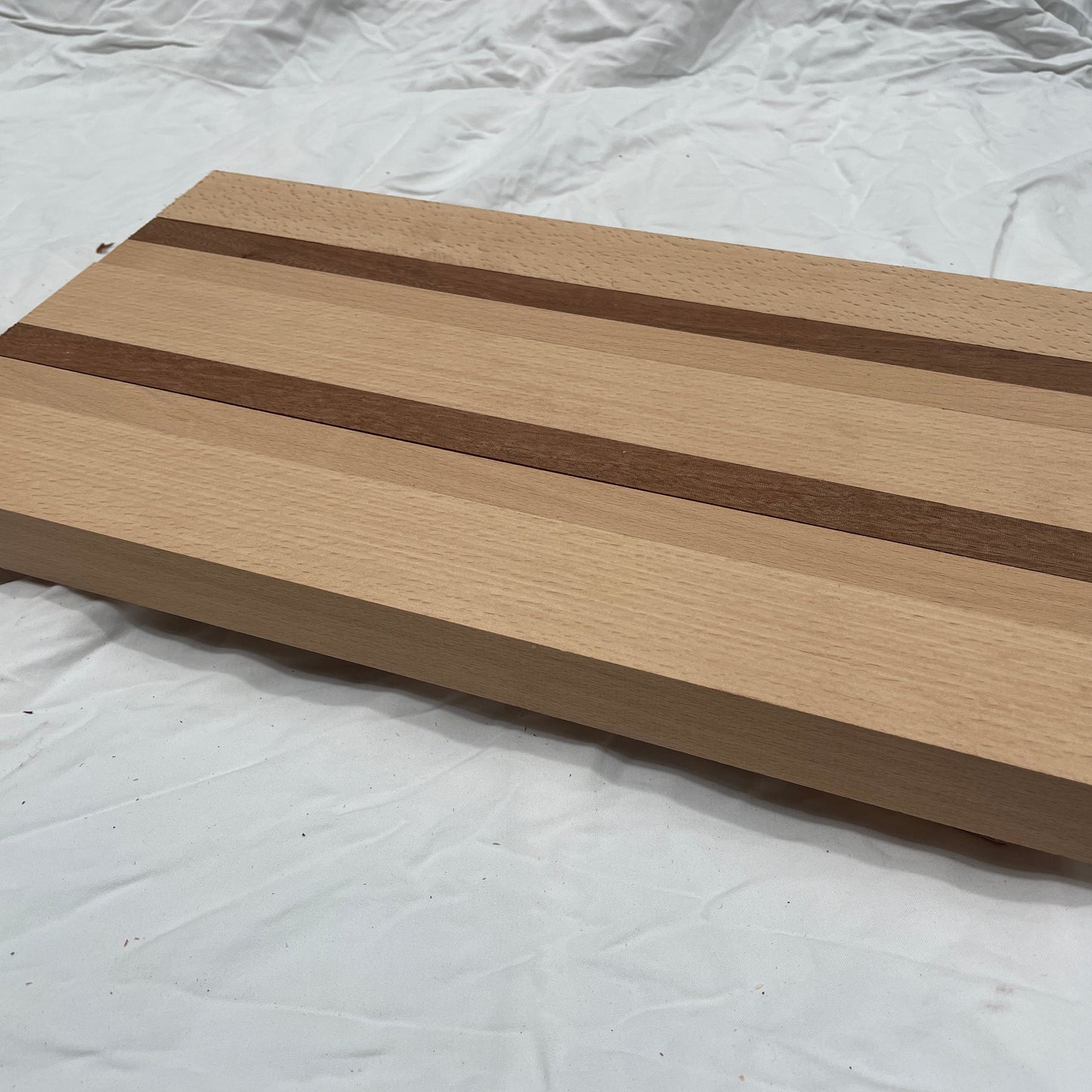 Wooden cutting board with a striped pattern on a white background