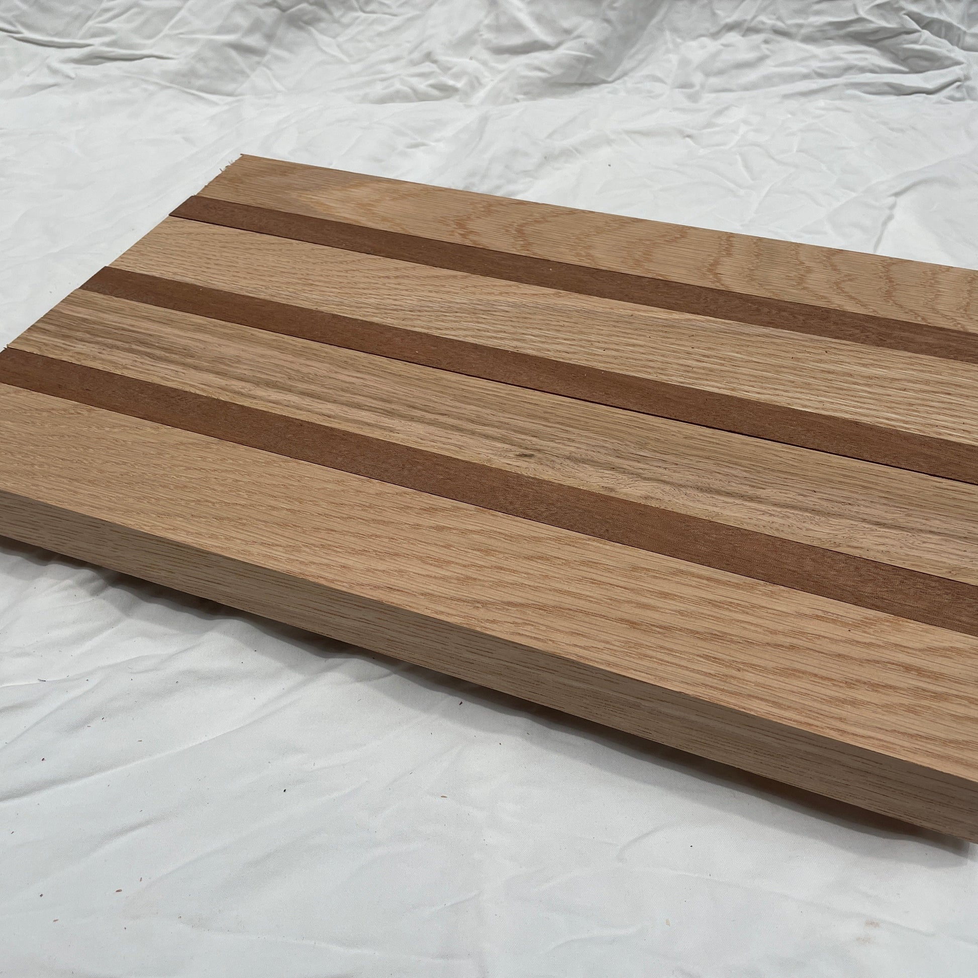Wooden cutting board with striped pattern on a white background